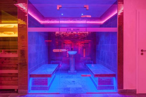 a room with two benches in a room with purple lights at FOR MOMENTS Apartments & Spa in Roßhaupten