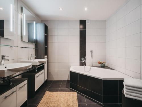 a bathroom with a tub and two sinks at Residence Kristall by VAYA in Saalbach-Hinterglemm