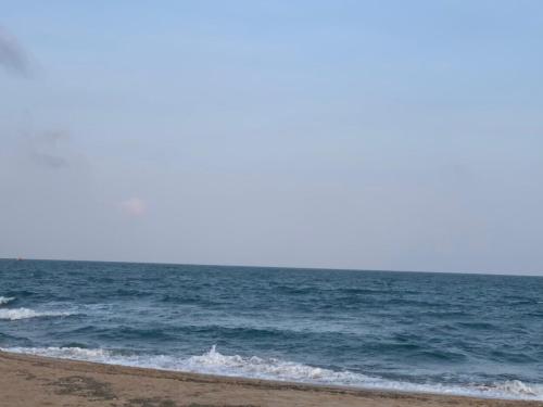 a person walking on the beach near the ocean at Villas at Oceanami Resort in Long Hai
