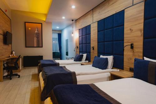 Cette chambre comprend une rangée de lits et un bureau. dans l'établissement Grand Catalkaya Hotel, à Erzurum