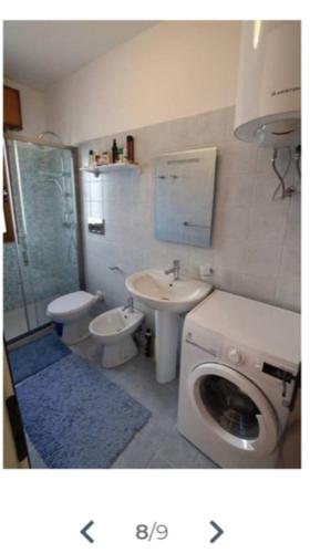 a bathroom with a toilet and a sink and a toilet istg at Bilocale Kenya in Caorle