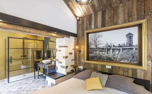 a bedroom with a bed and a bathroom with a sink at Le Gîte des Platanes in Spa