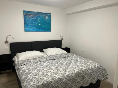 1 dormitorio con 1 cama y una pintura en la pared en Apartma Toni Bovec, en Bovec