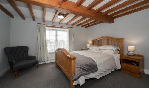 a bedroom with a bed and a chair and a window at Vivers Mill in Pickering