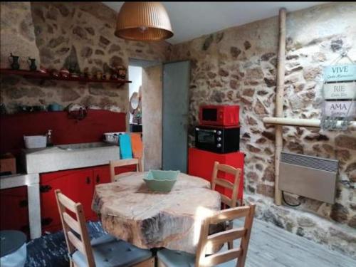 a kitchen with a wooden table with chairs and a stove at Moinho Azenha do campelo in Vila Verde