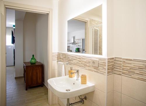 ein Badezimmer mit Waschbecken und Spiegel in der Unterkunft CENTRAL STATION APARTMENTS - Fanale Rentals in Palermo