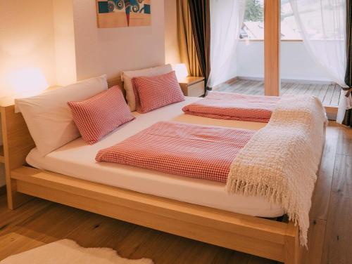 a bed with two pillows on it in a room at Ciasa Irene App Mansarde in La Villa