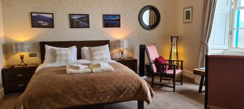 a bedroom with a bed with two towels on it at CREAG DHUBH COUNTRY HOUSE in Inveraray