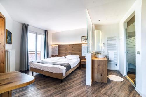 a bedroom with a bed and a desk and a mirror at Hotel Montana in Vason