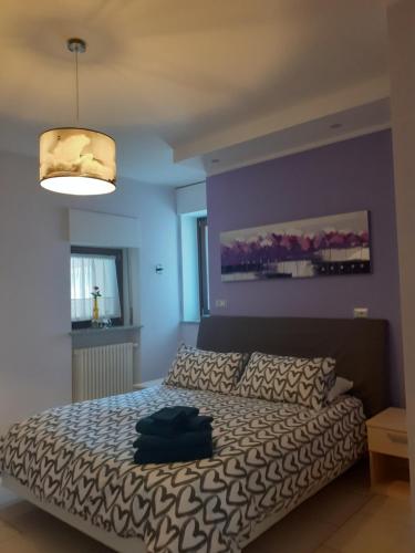 1 dormitorio con cama y pared púrpura en B&B Mary, en Alba