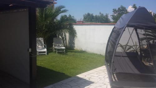 un cortile con due sedie e una recinzione di Casa Daniela a San Felice Circeo
