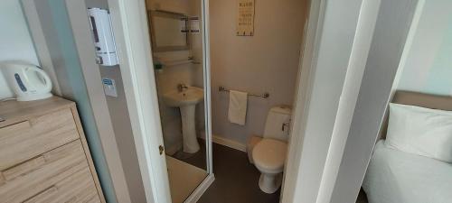 a small bathroom with a toilet and a sink at Four Seasons Guest House in Blackpool