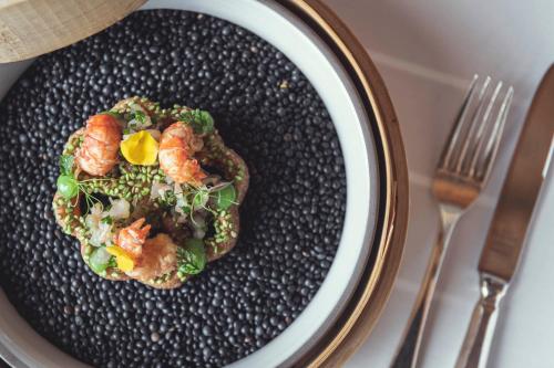 a plate of food with shrimp and vegetables on it at Schlosshotel Ischgl 5-Sterne Superior in Ischgl