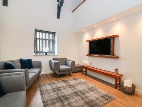 a living room with two couches and a flat screen tv at The Reception Room at The Institute Executive Apartments in Keith