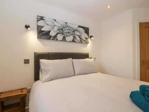 a bedroom with a white bed with a picture on the wall at The Dance Hall at The Institute Executive Apartments in Keith