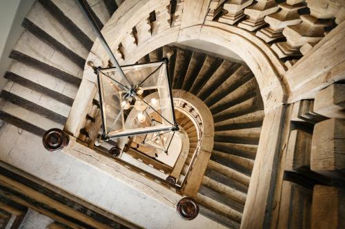 a spiral staircase in a building with a chandelier at Edgar Suites Louvre - Jour in Paris