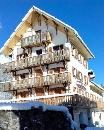 - un bâtiment avec des balcons en bois sur le côté dans l'établissement Auberge du Glandon, à Saint-Colomban-des-Villards
