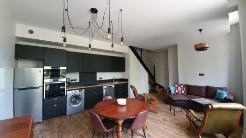 a kitchen and living room with a table and a couch at Château Belle Epoque - Chambres d'Hôtes & Gîtes in Linxe