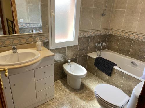 a bathroom with a sink and a toilet and a tub at Casa a L’Escala, piscina comunitaria, Mallols in L'Escala