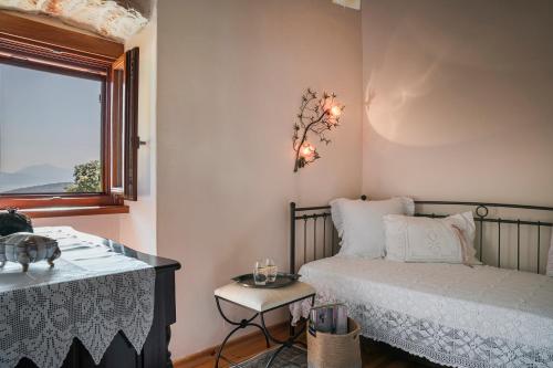 a bedroom with a bed and a table and a window at Traditional Stone House Anofli 1843 Fiskardo Kefalonia in Fiskardho