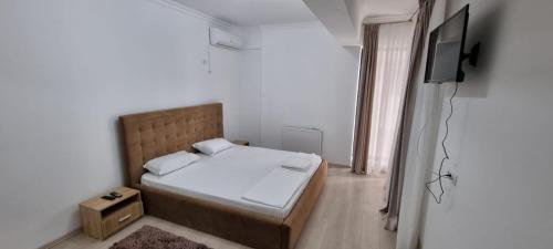 ein kleines Schlafzimmer mit einem Bett und einem TV in der Unterkunft Apartament 2 camere cu 2 bai Mamaia Butoaie in Mamaia