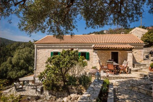 a small stone house with a table and chairs at Traditional Stone House Anofli 1843 Fiskardo Kefalonia in Fiskardho