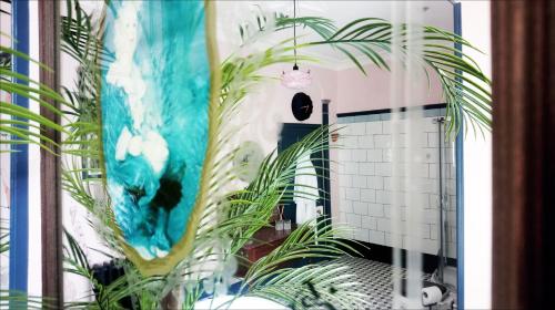 uma casa de banho com um espelho e uma planta em Little Robin B&B em Dufftown