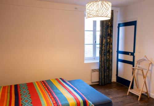 - une chambre avec un lit, une fenêtre et une échelle dans l'établissement Appartement Saint-Sauveur, à Dinan