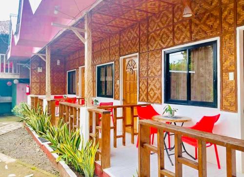 a restaurant with red chairs and tables in a building at Domos Native Guest House in Panglao