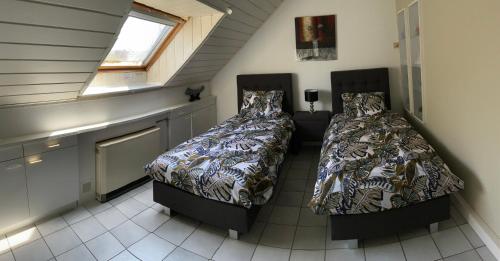 two beds in a small room with a counter at LinZn vakantiehuis in Wuustwezel