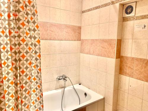 a bathroom with a tub and a shower curtain at Jazzy Vibes Parliament Rooms and Ensuites in Budapest