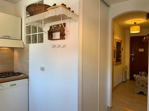 einen weißen Kühlschrank in einer Küche neben einem Flur in der Unterkunft Casa Orchidea Bianca by Holiday World in Limone Piemonte