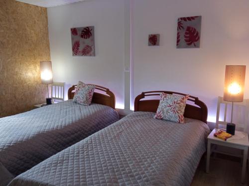 two twin beds in a room with two lamps at Azevinho Guest House in Seia