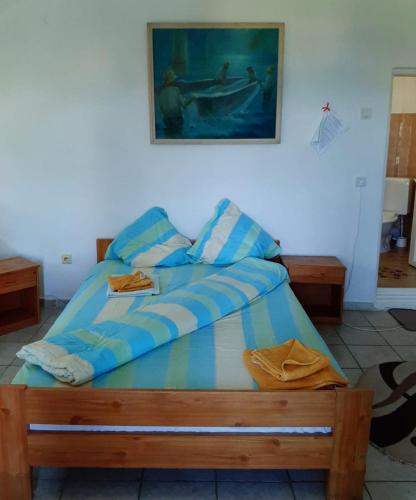 a bed in a room with a picture on the wall at Pensiunea Sapte Pini in 2 Mai