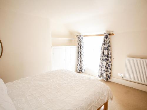 1 dormitorio con cama y ventana en Tudor Cottage, en Conwy