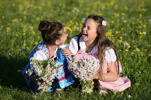 two little girls sitting in a field with flowers at MONDI Resort und Chalet Oberstaufen in Oberstaufen