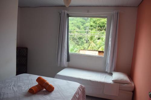 um quarto com 2 camas e uma grande janela em Pousada Guest House Rota 027 Morro de São Paulo em Morro de São Paulo