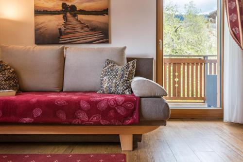 a couch sitting in a living room next to a window at Huberhof App Rubens in Feldthurns