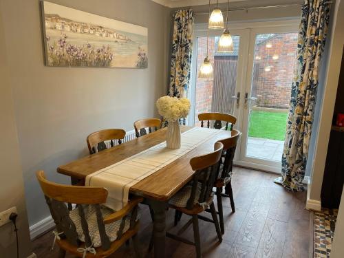 a dining room with a wooden table and chairs at Tranquil 3 bedroom town house with Sky Sports in Thornton