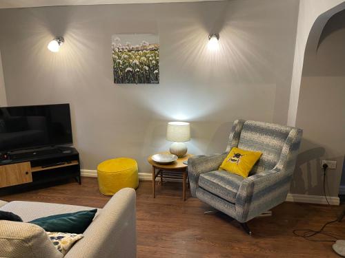 a living room with a couch and a chair and a television at Tranquil 3 bedroom town house with Sky Sports in Thornton