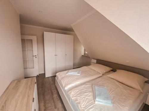een slaapkamer met een groot bed op zolder bij Inselperle Kämmererhof in Fehmarn