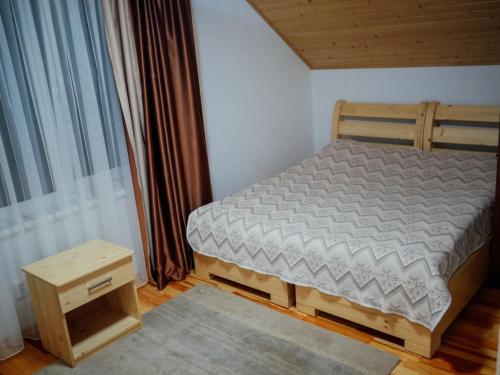 a small bedroom with a bed and a table at Villa Med'OK in Vyzhnytsya