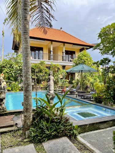 a resort with a swimming pool in front of a building at PGS HOME STAY in Ubud