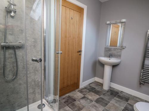 a bathroom with a shower and a sink at Talarddu Cottage in Builth Wells