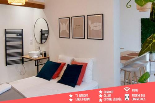 Cette chambre dispose d'un canapé blanc et d'oreillers colorés. dans l'établissement Artpink - Idéal Pros - Proche commerces - Agathor, à Montluçon