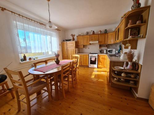 a kitchen with a table and chairs and a kitchen with wooden cabinets at Cottage next Svihov castle in Švihov