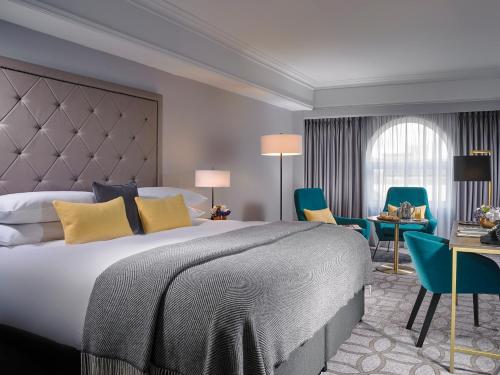 Habitación de hotel con cama, escritorio y sillas en The Davenport en Dublín