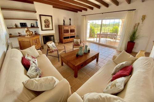 a living room with two white couches and a table at Villa PALMERA in Sant Jordi