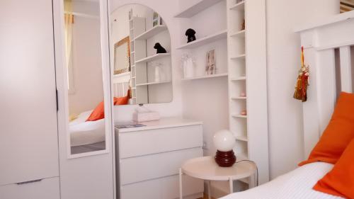 Dormitorio pequeño con cama y espejo en Habitación con baño privado en piso familiar, en Alicante