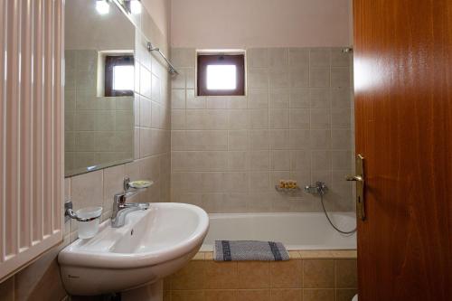 uma casa de banho com um lavatório e uma banheira em Villas Roumeli em Roumelí